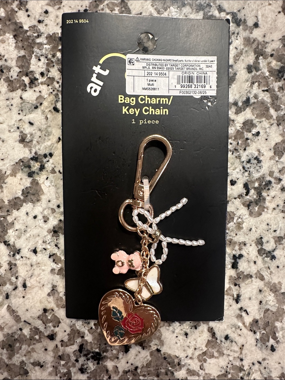 Art Bag charm gold tone keychain with pink bear, white butterfly, and white bow.